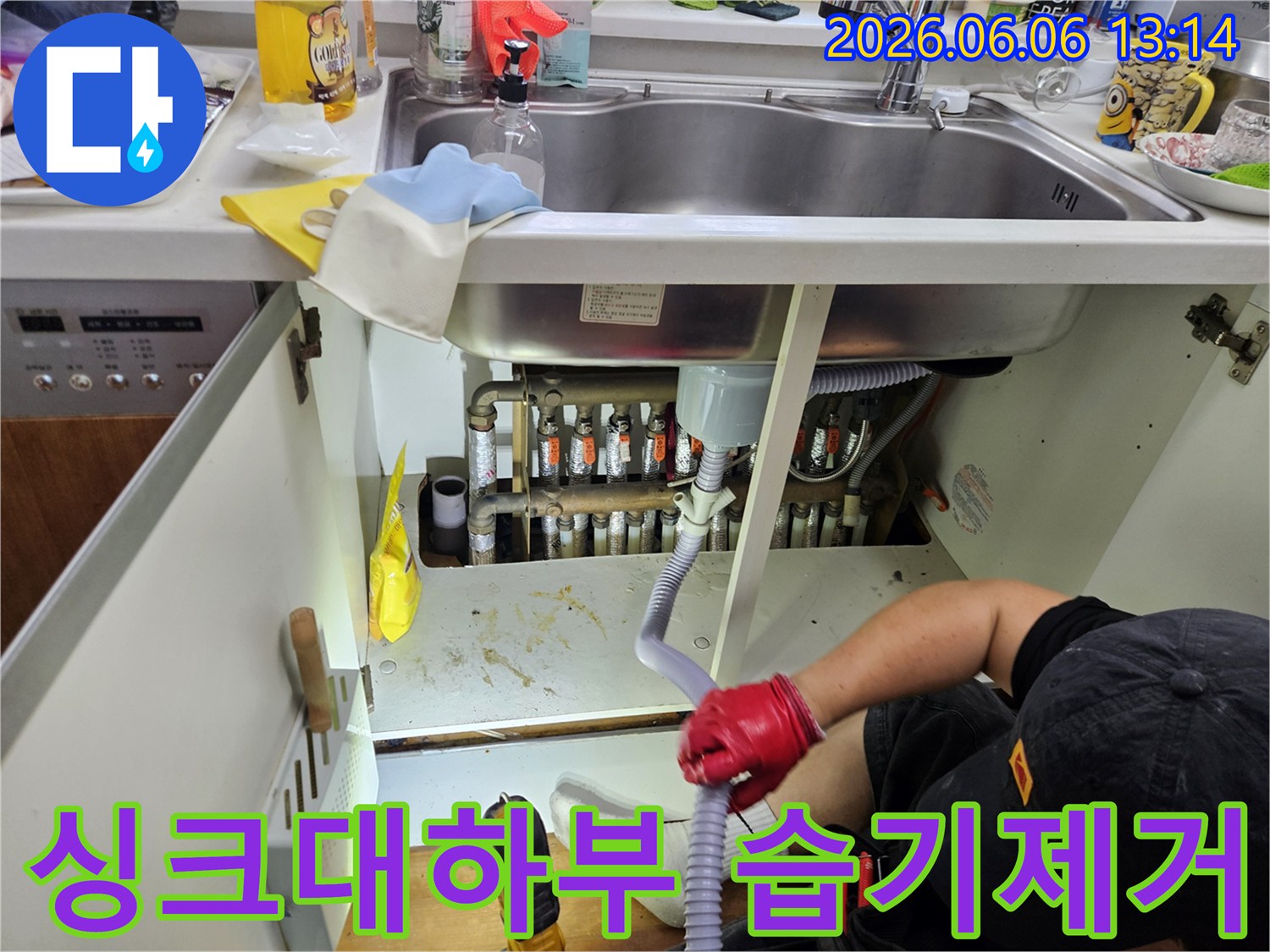 누수-전문가가-싱크대-아래-하부장-내부의-습기를-확인하며-건조-작업을-준비하고-있습니다