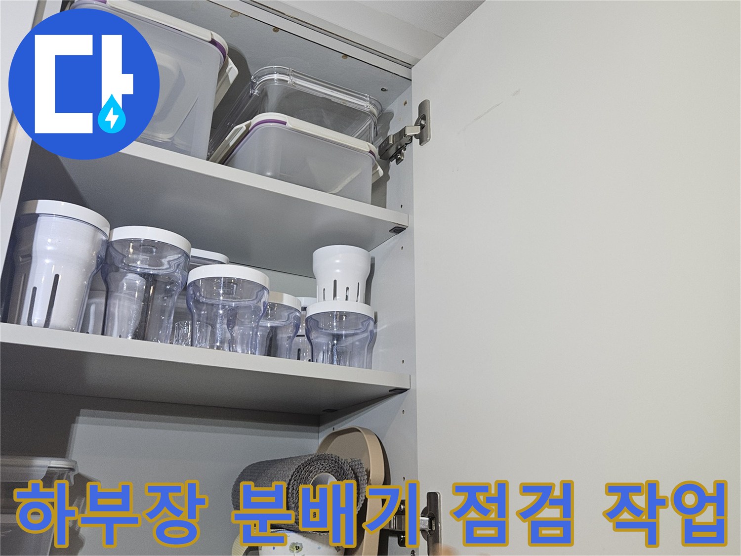 싱크대 하부장 내부의 분배기와 연결된 배관들을 살피는 모습