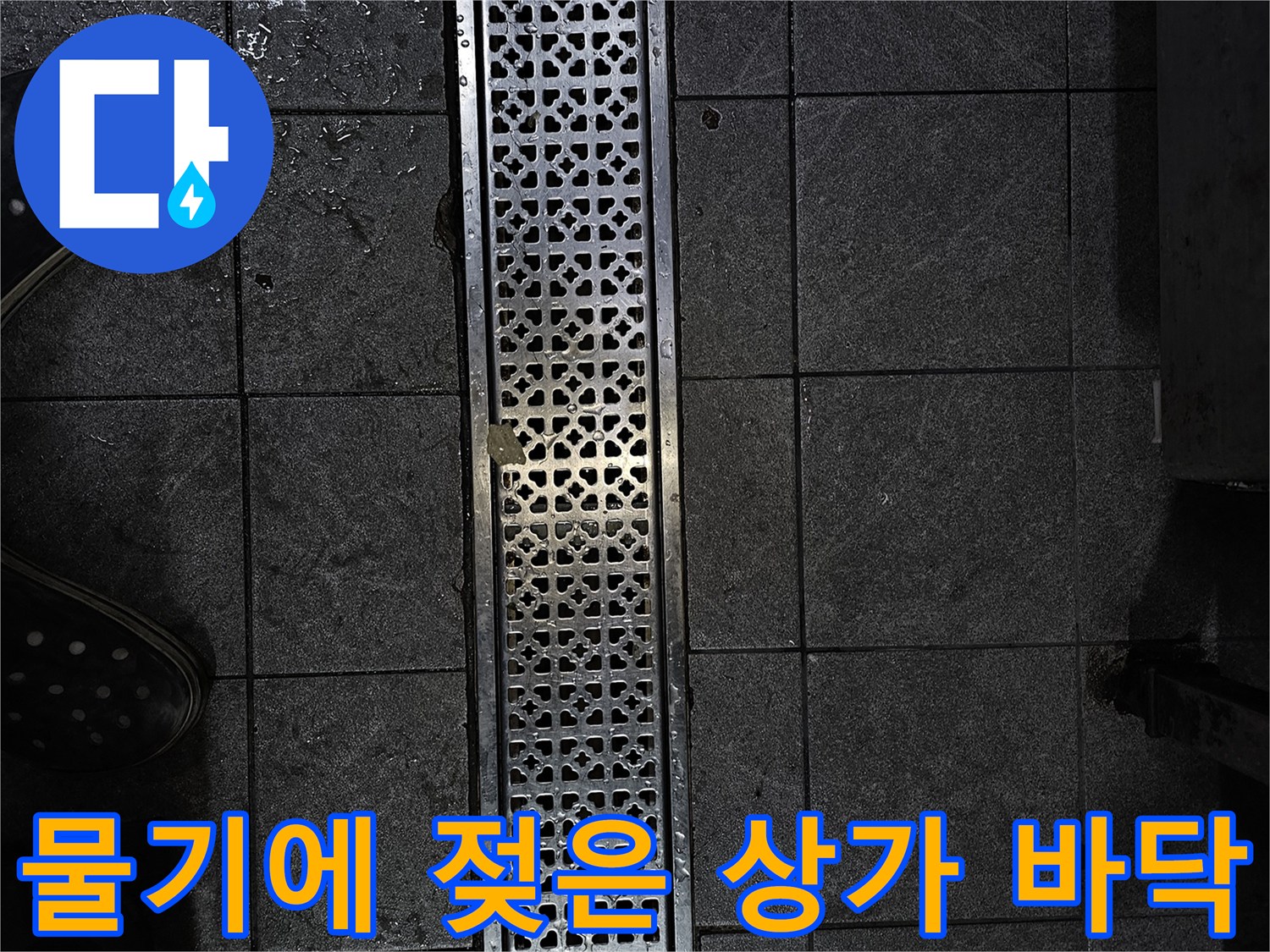 습기를 머금어 어두워진 매장 내부 타일과 금속 배수구