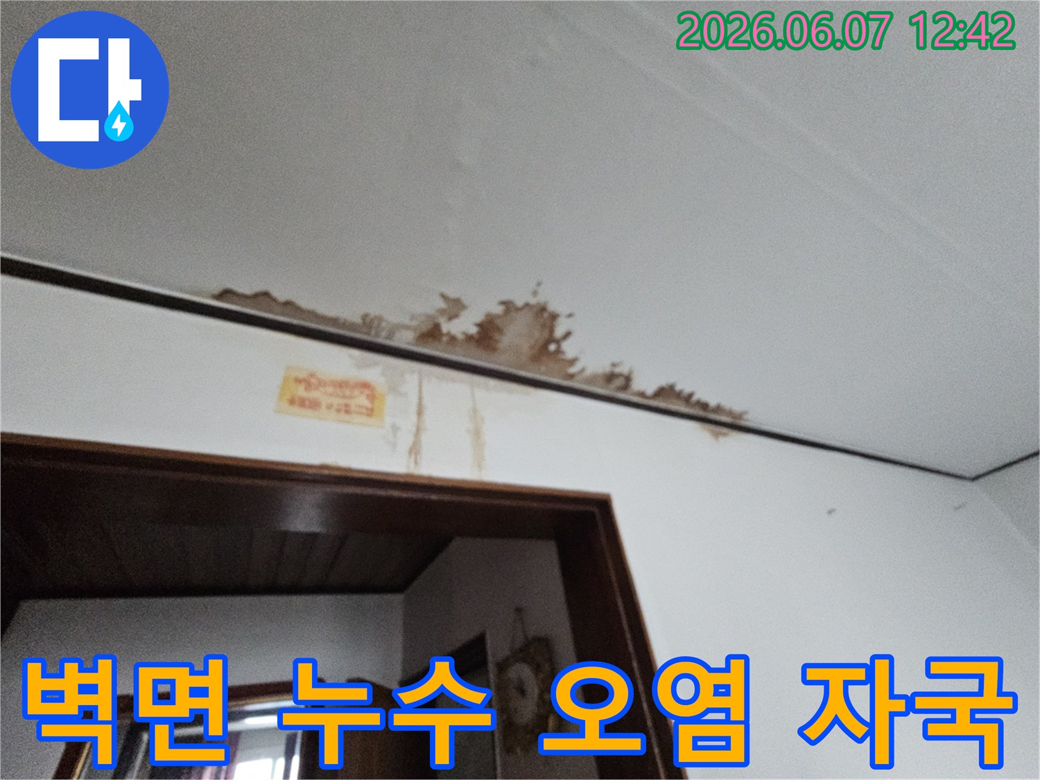 벽면과 천장 모서리에 나타난 심각한 물 얼룩과 손상된 페인트를 보여주는 현장 사진입니다