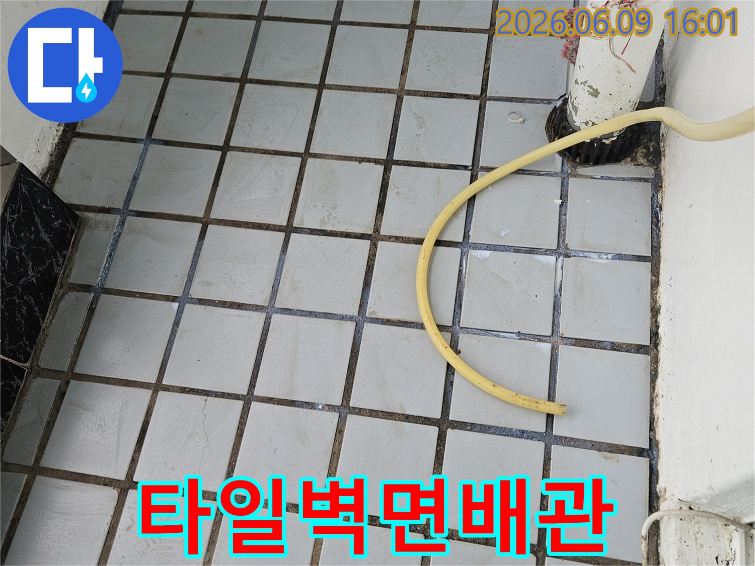 배관 누수 탐지 작업 중-타일 벽면과 배관 주변에-놓여있는 노란색 호스
