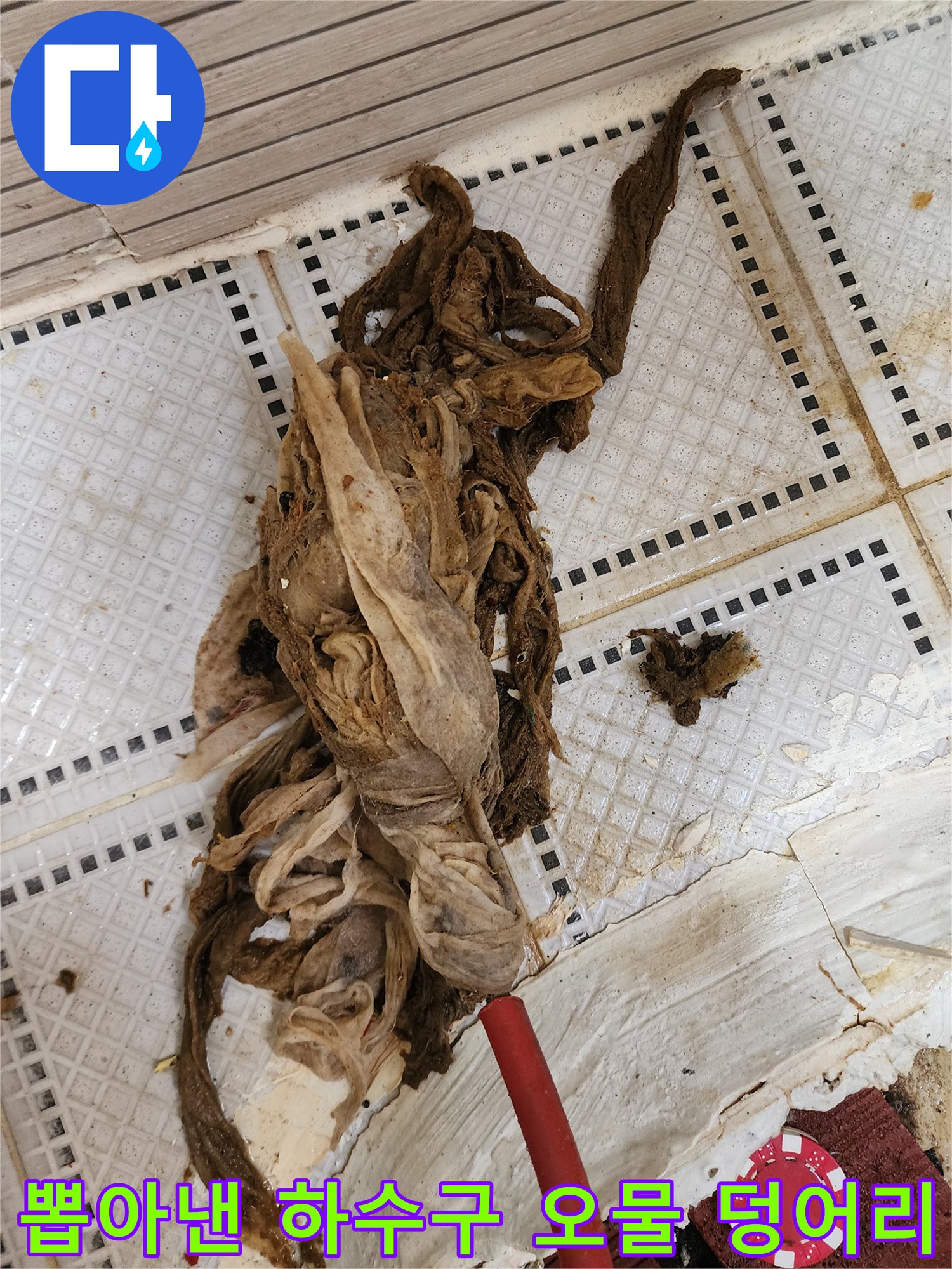 배관 작업 후 타일 위에 놓인 거대한 머리카락 섬유 뭉치