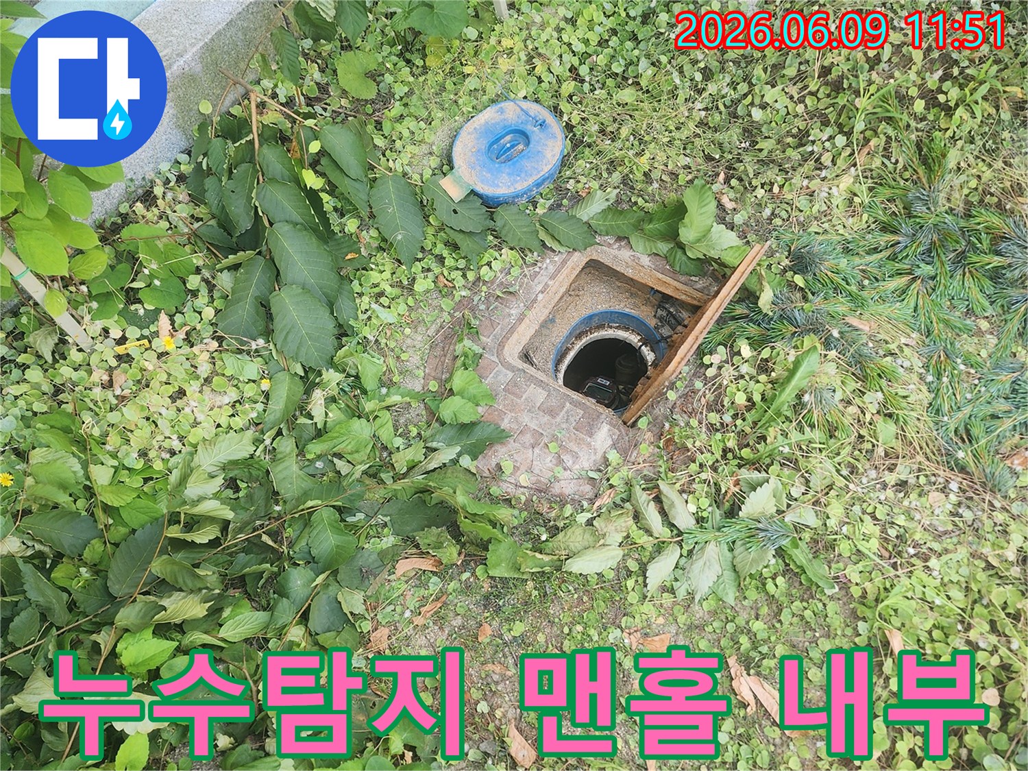 누수 탐지를 위해-땅속에 설치된-맨홀의 뚜껑을 열고-내부 배관의-상태를 면밀히-살펴보는-작업 현장입니다