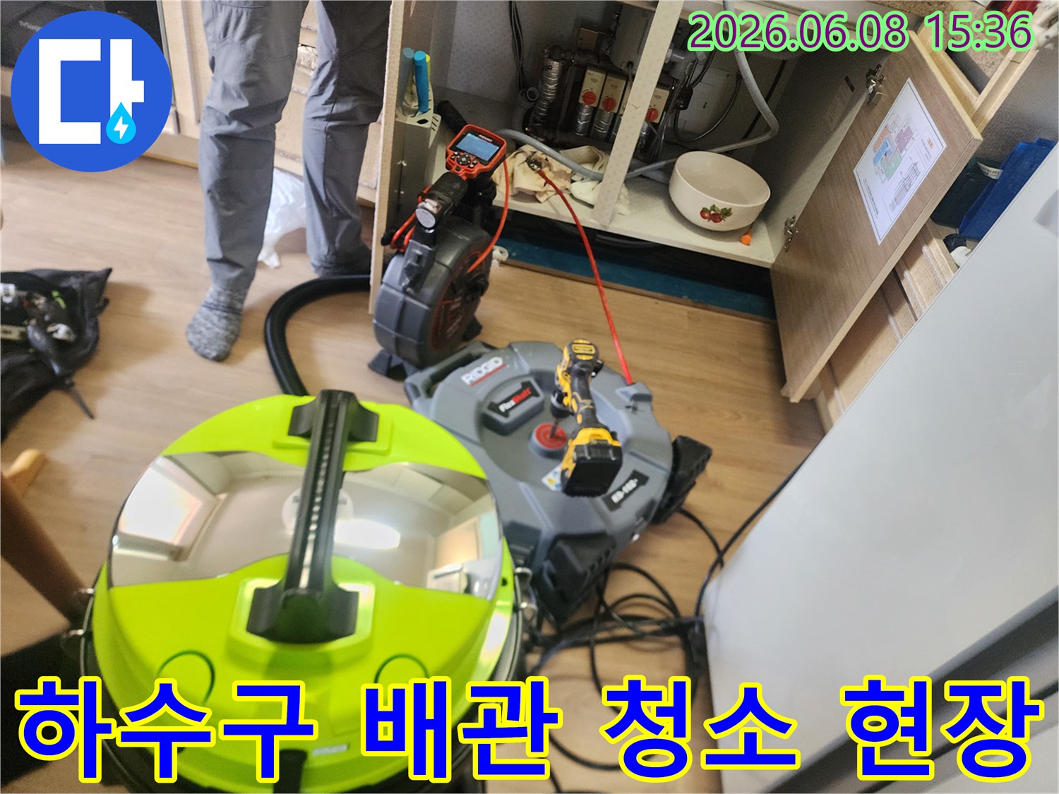 싱크대 하부장의 막힌 배관을 뚫기 위한 장비 세팅 모습