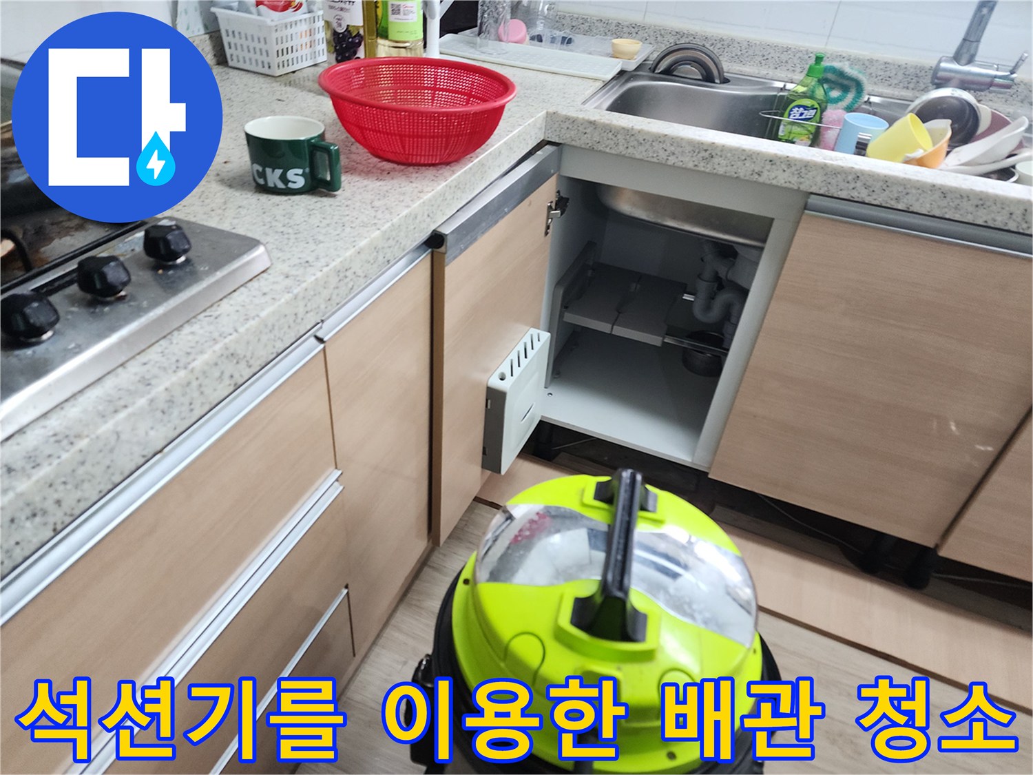 싱크대 하부장 공간에 설치된 노란색 석션 장비와 분리된 배관