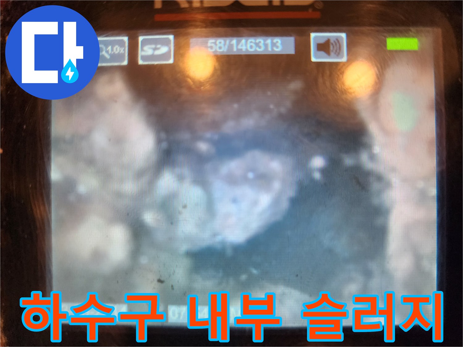 배수구 통로를 막고 있는 하얀색 석회와 슬러지 덩어리