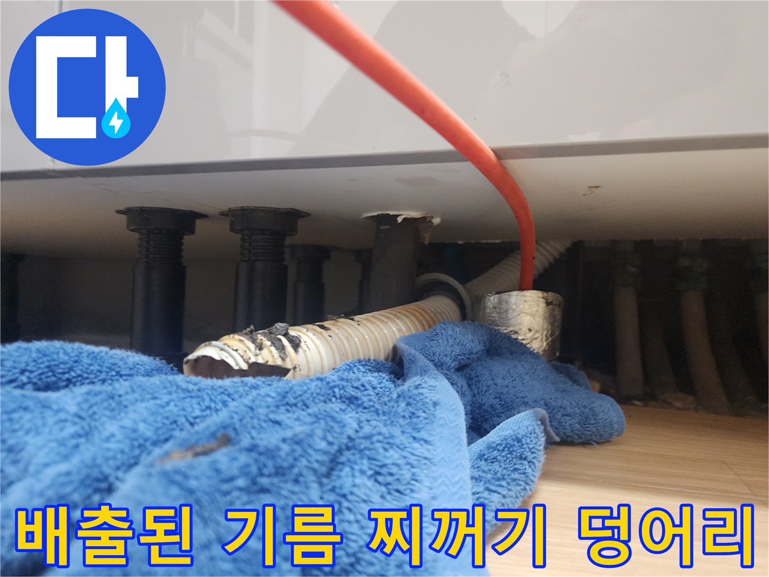 배관 내부에서 제거된 검은색 기름 슬러지 덩어리와 배수 호스