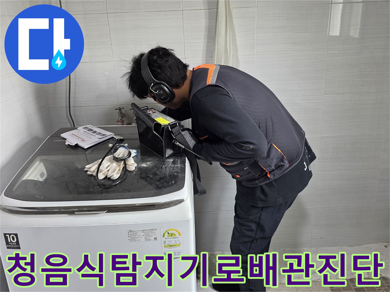 소음차단 헤드셋을 착용한 엔지니어가 청음식 탐지기를 사용하여 세탁기 주변 배관의 미세한 물샘 소리를 추적하고 있습니다.