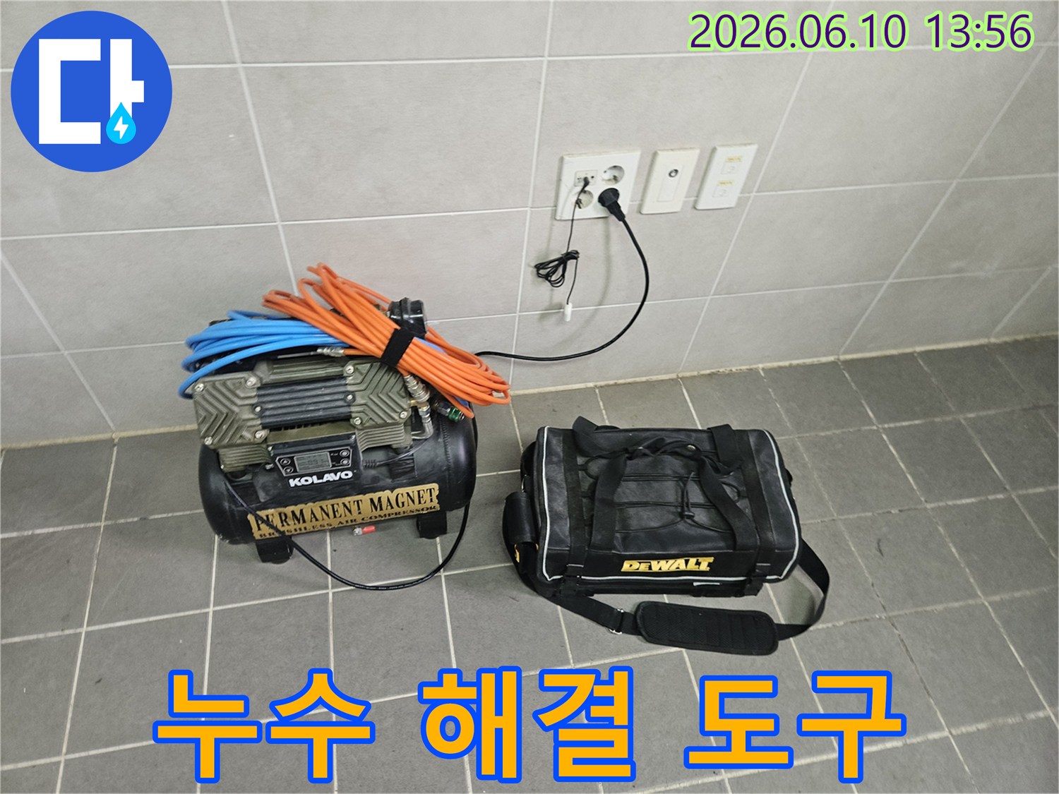 누수 공사의 완벽한 수행을 위해-누수 전문가가-배관 압력 테스트용 콤프레셔와-수리 공구 가방을-작업 현장에 배치했습니다.
