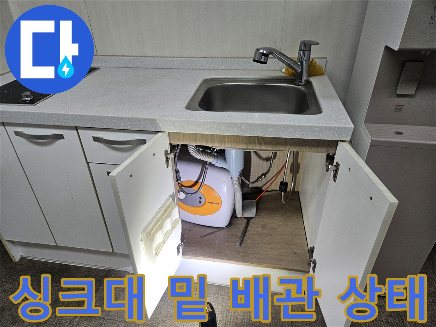 싱크대 하부 수납장 내부의 세탁기 급배수 호스 및 부속품