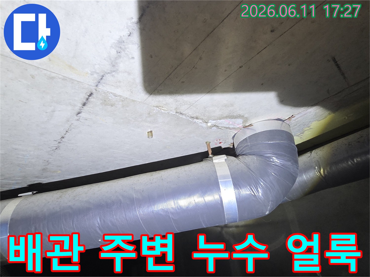 회색 배관과 연결된 천장 부위에서 나타난 물 얼룩과 손상 흔적을 상세히 보여주는 이미지