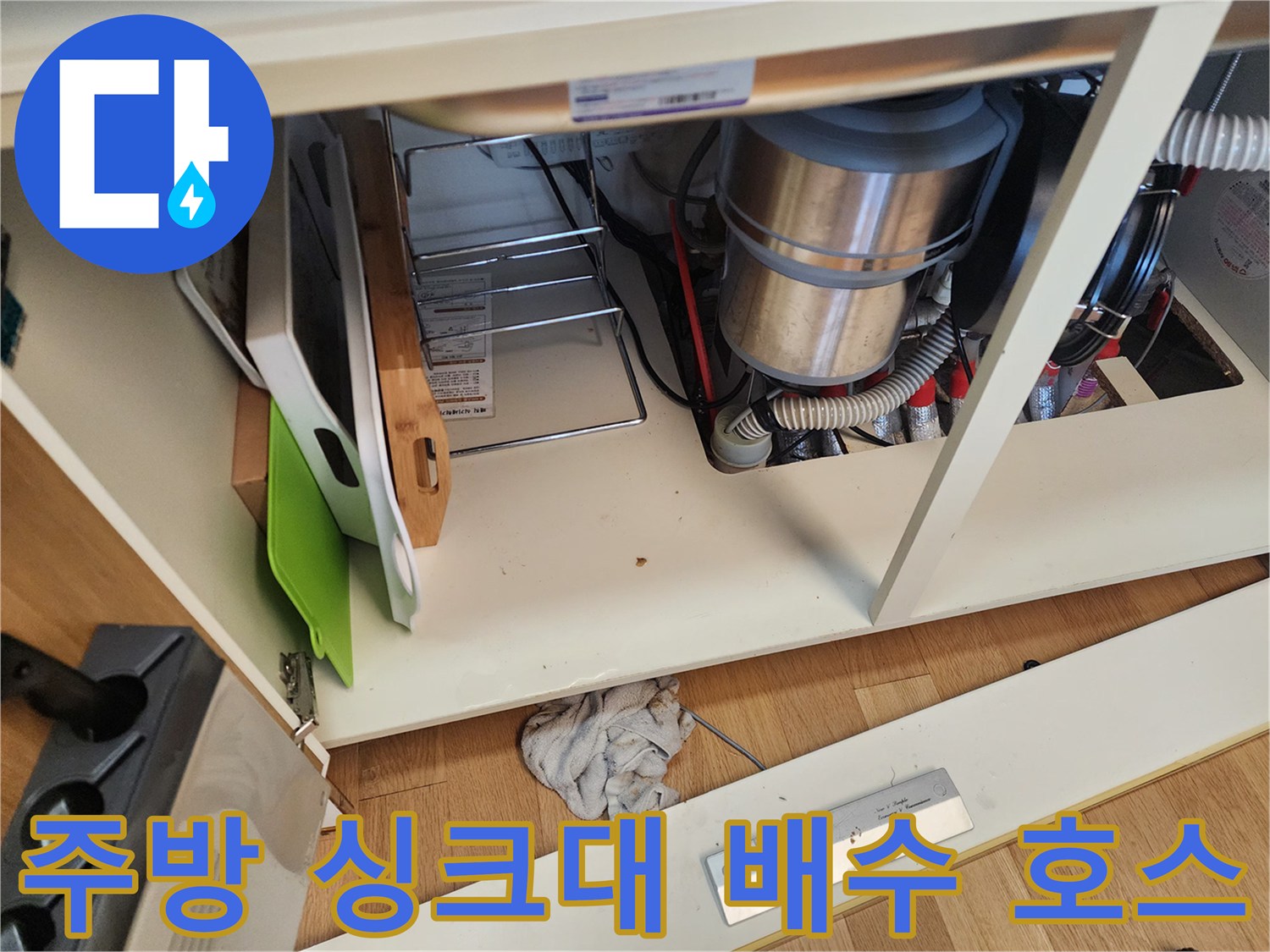 싱크대 하부장 내부의-연결된 배수관과 주름진 호스의 모습
