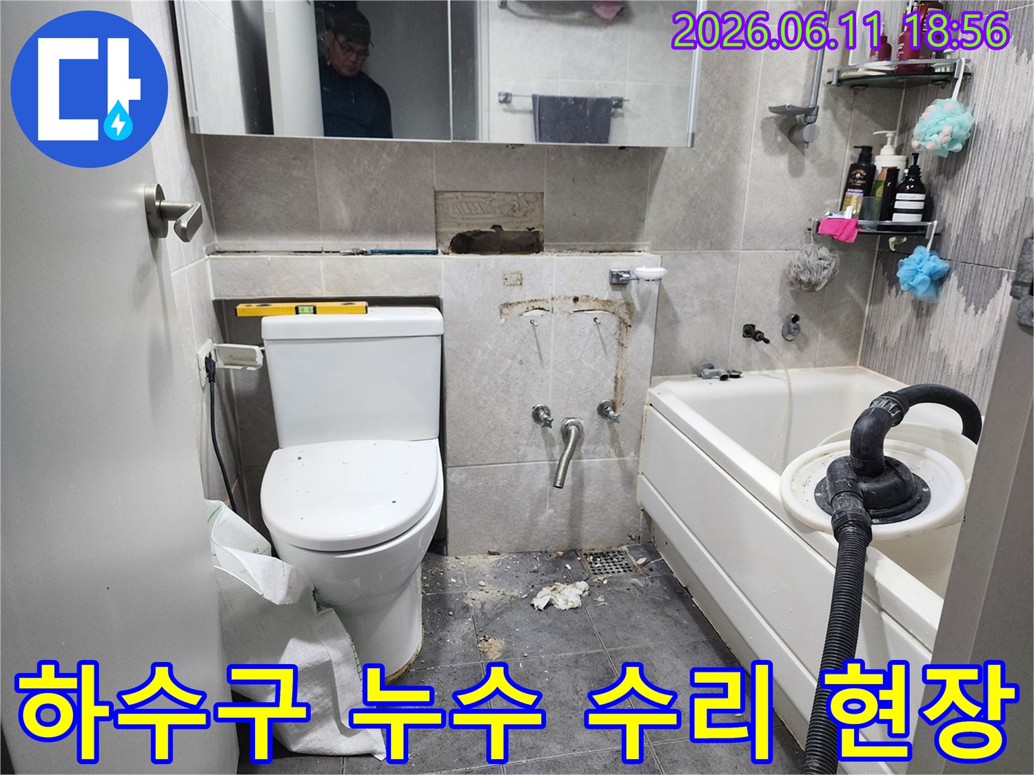 이 이미지는-동대문구의 한 화장실에서-하수구 배관의 누수 문제를 해결하기 위해-바닥 타일을 제거하고-손상된 하수구 배관을 수리하는-작업 현장을 보여줍니다