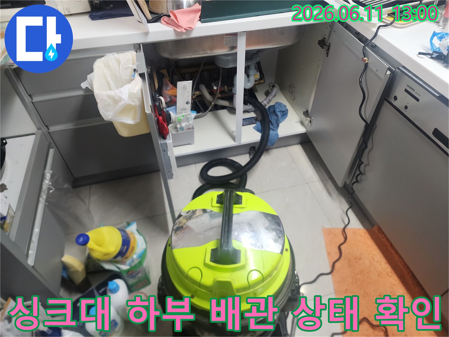 싱크대 아래쪽 배수관과 작업용 청소 장비의 배치 상황