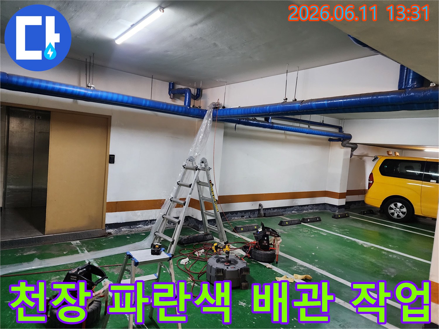 지하주차장 천장의-파란색 배관과 작업용 사다리 설치 모습