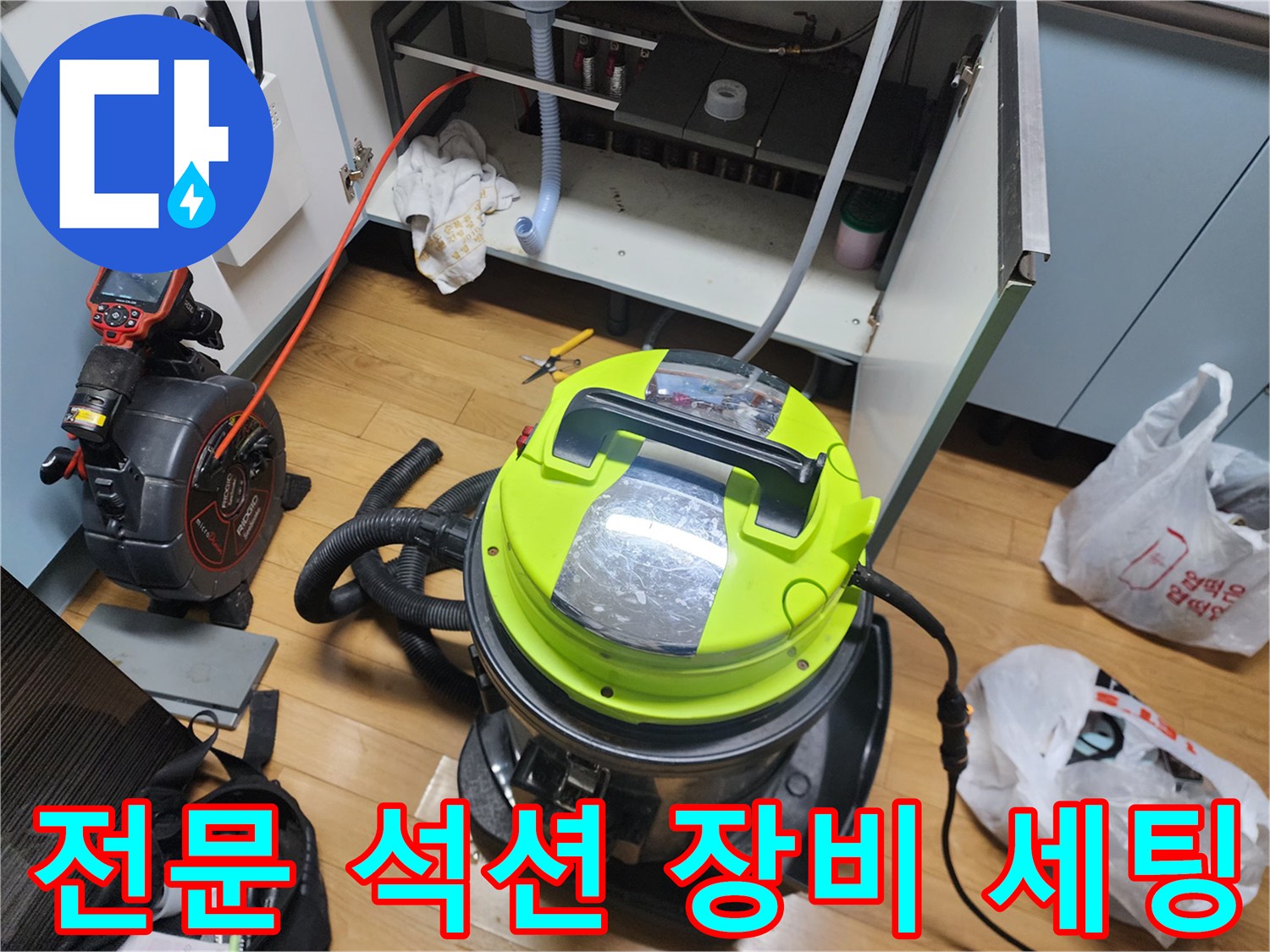 배수관 청소를 위해 싱크대 하부에 배치된 강력 석션기와 호스