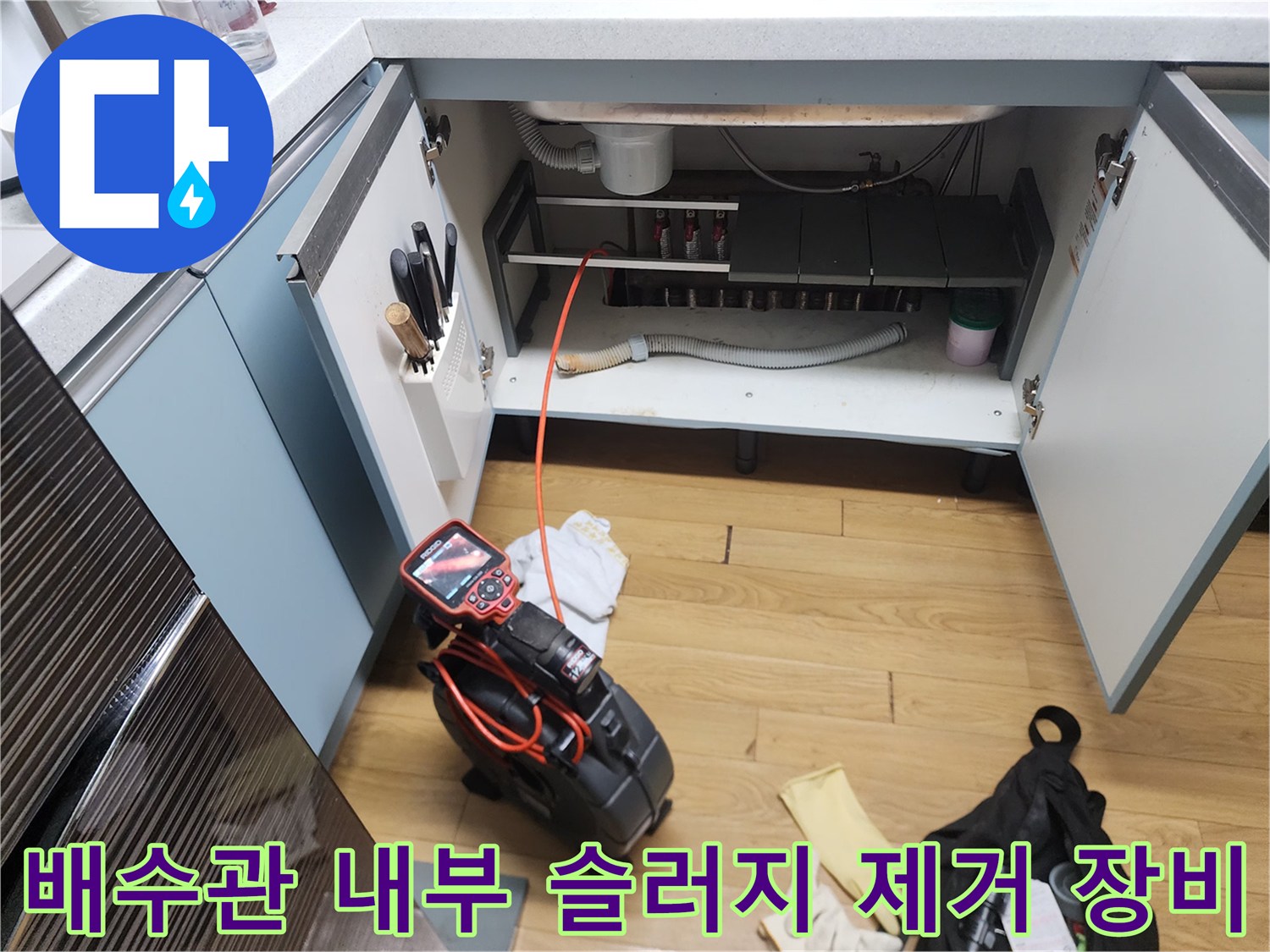 싱크대 아래쪽 배관 점검을 위해 배치된 석션기와 내시경 카메라