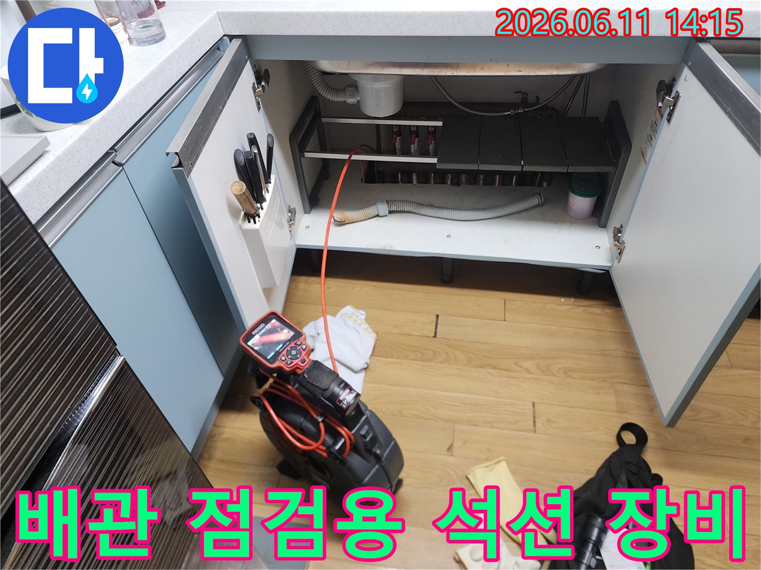 싱크대 하부 배수관 아래에 놓인 강력한 흡입력을 가진 석션 장비와 내시경 모니터