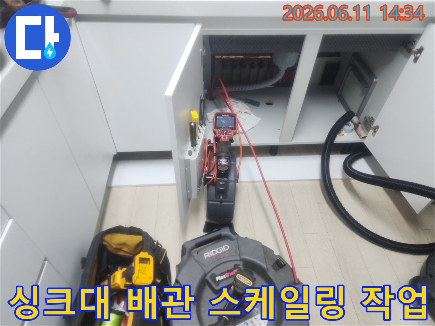 남양주 평내동 싱크대 하부장 내부에서 진행 중인 배관 스케일링 장비 모습