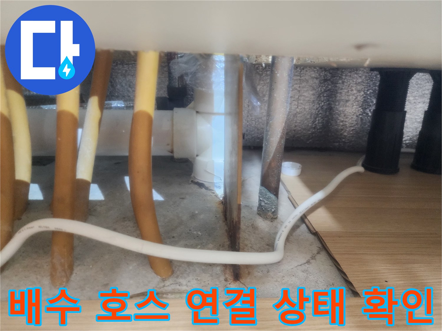 노란색 싱크대 배수 호스와 바닥 하수구 부위의 상세 모습