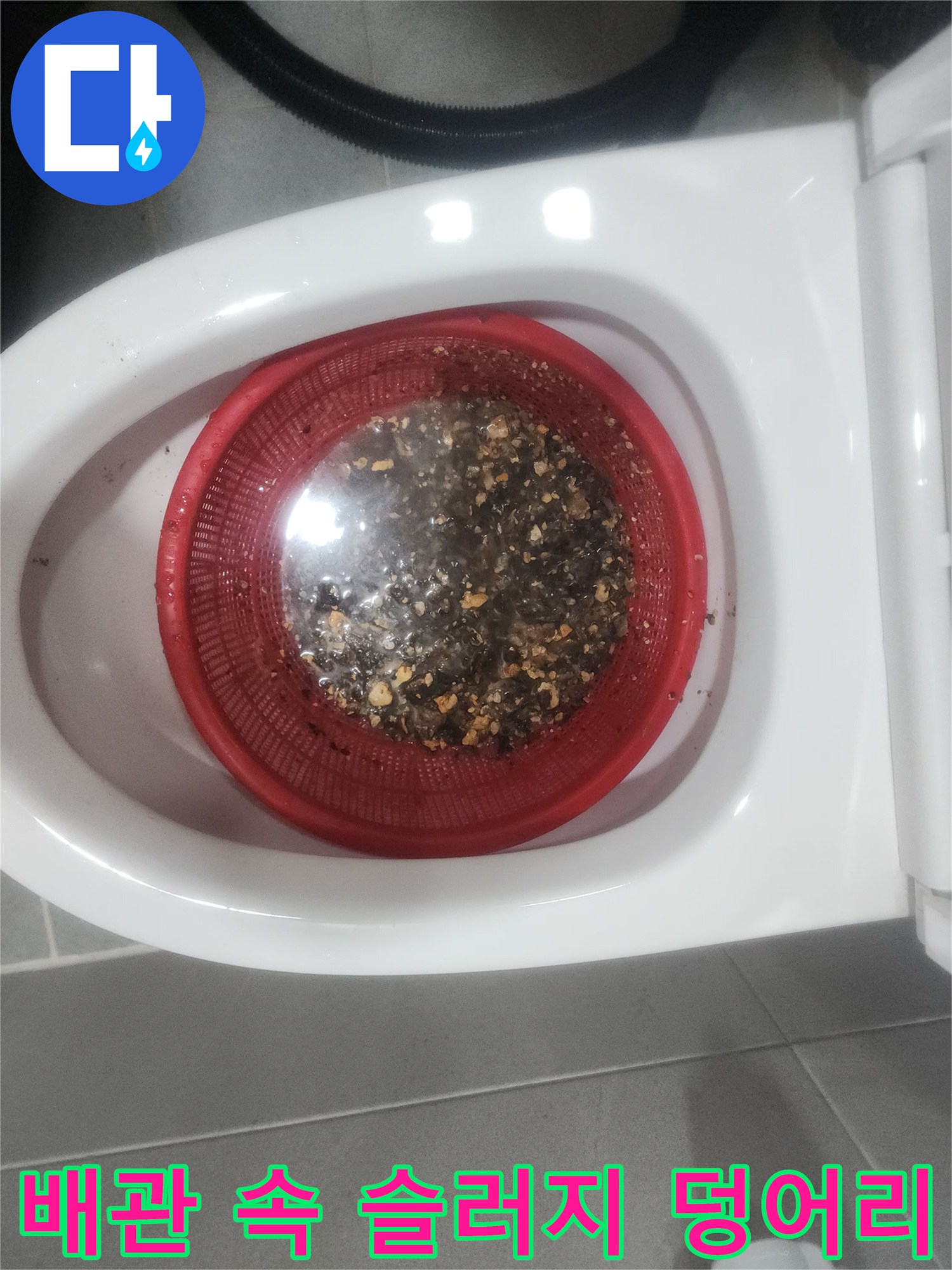 붉은색 거름망에 걸러진 배관 내부의 검은색 슬러지와 오물들