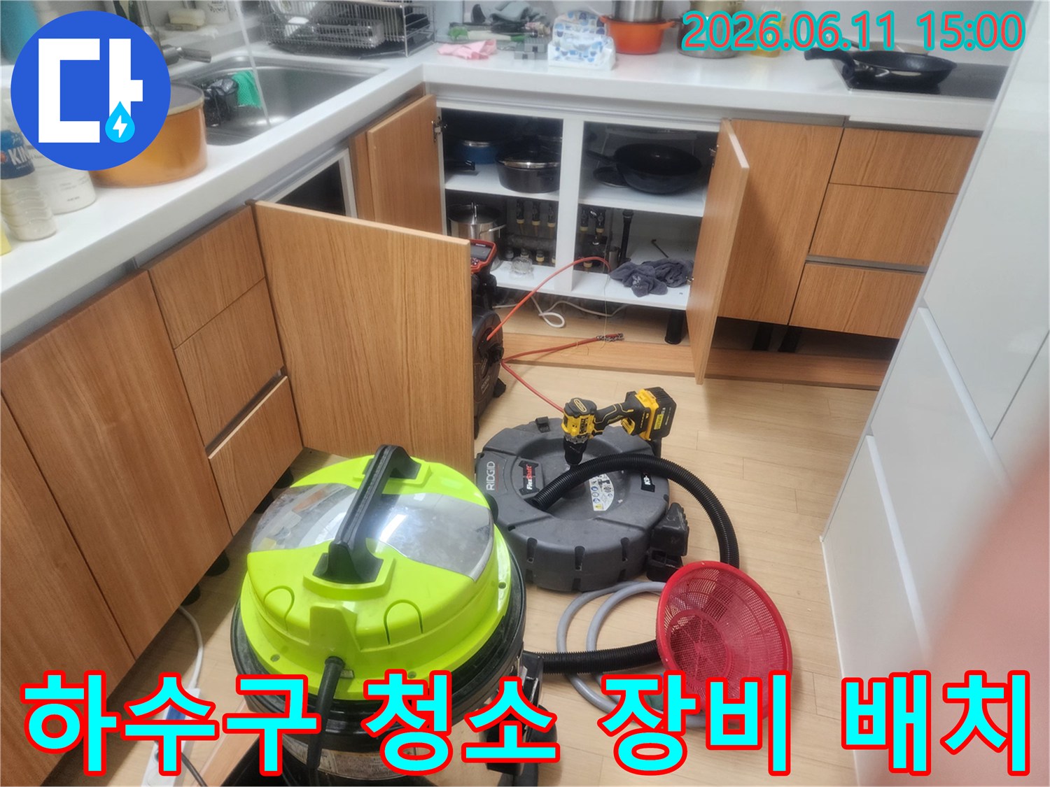 싱크대 하부장 밑에 설치된 배관 흡입기 및 청소용 부품들