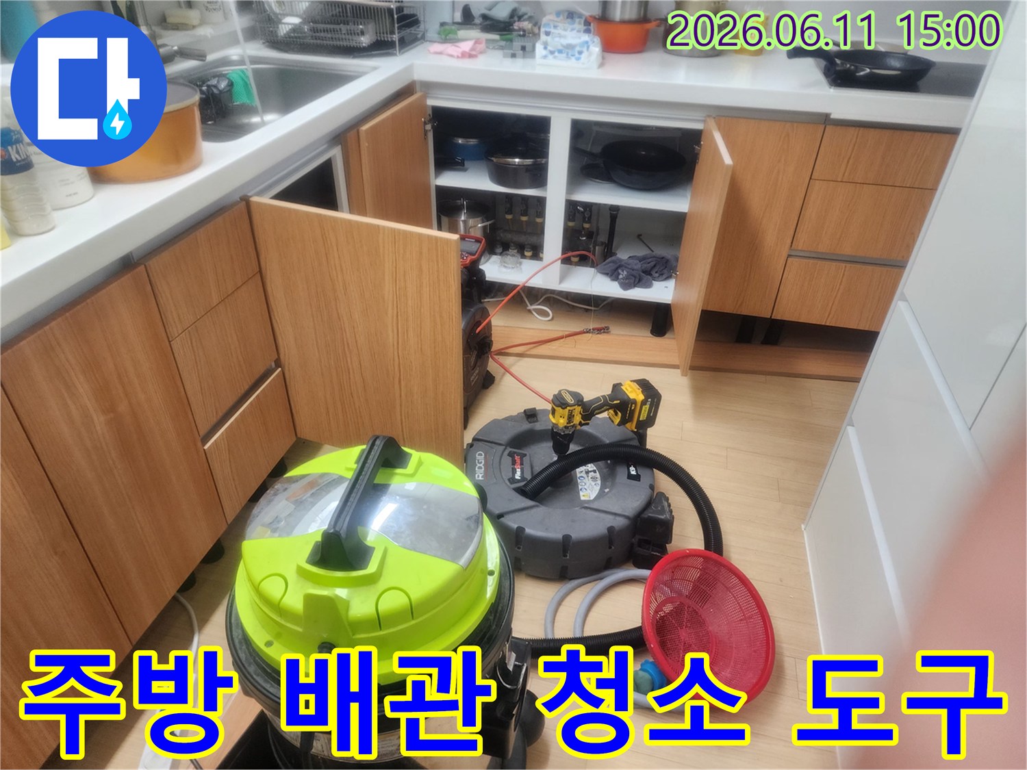 싱크대 하부장 아래에 준비된 노란색 배관 흡입 및 청소용 장비들