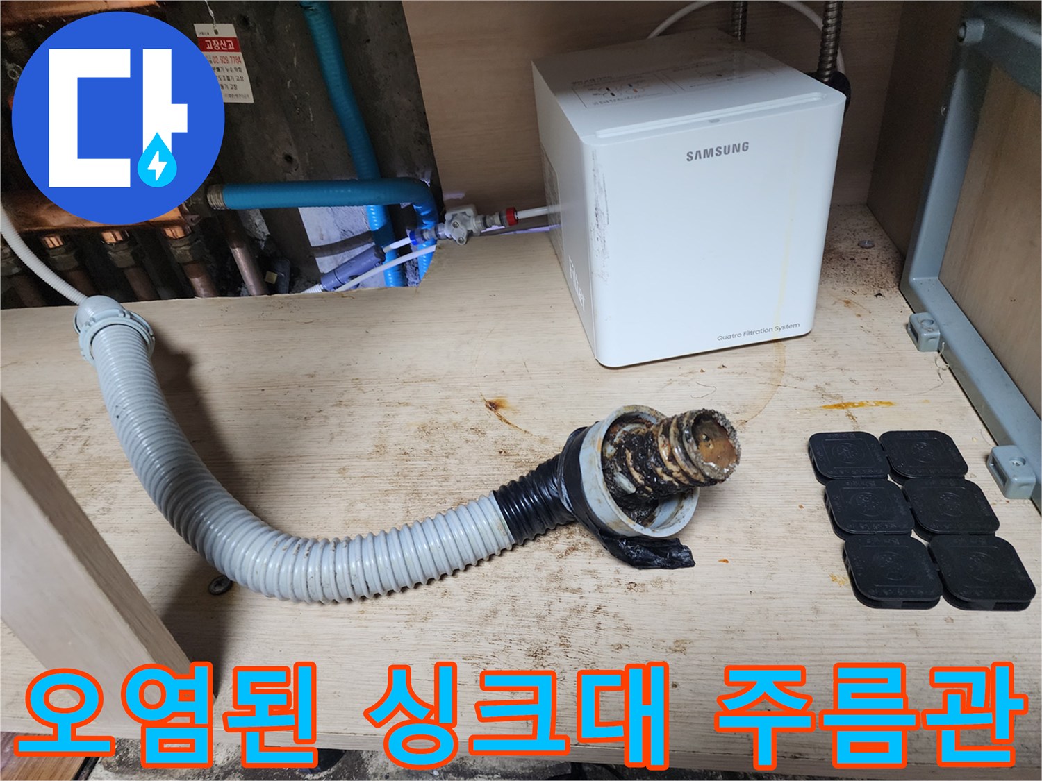 기름때로 오염된 싱크대 하부 배관과 주름관 모습