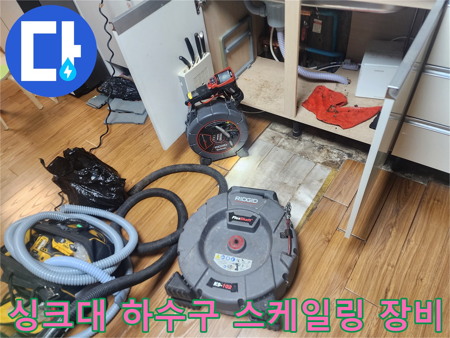 주방 싱크대 아래 배관 작업을 위해 배치된 리지드 스케일링 기계와 석션기