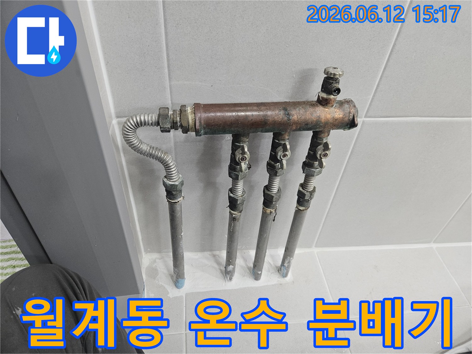 월계동 아파트의 온수 배관 분배기에서 누수 징후가 포착되어-전문가가 노후된 배관과 밸브 상태를 꼼꼼히 확인하고 있습니다