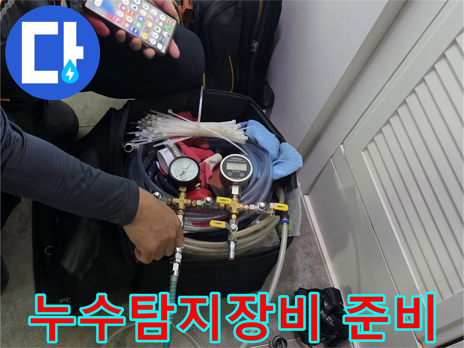 누수 탐지를 위해-전문 장비를 준비하고-스마트폰으로 현장 정보를 확인하는 모습