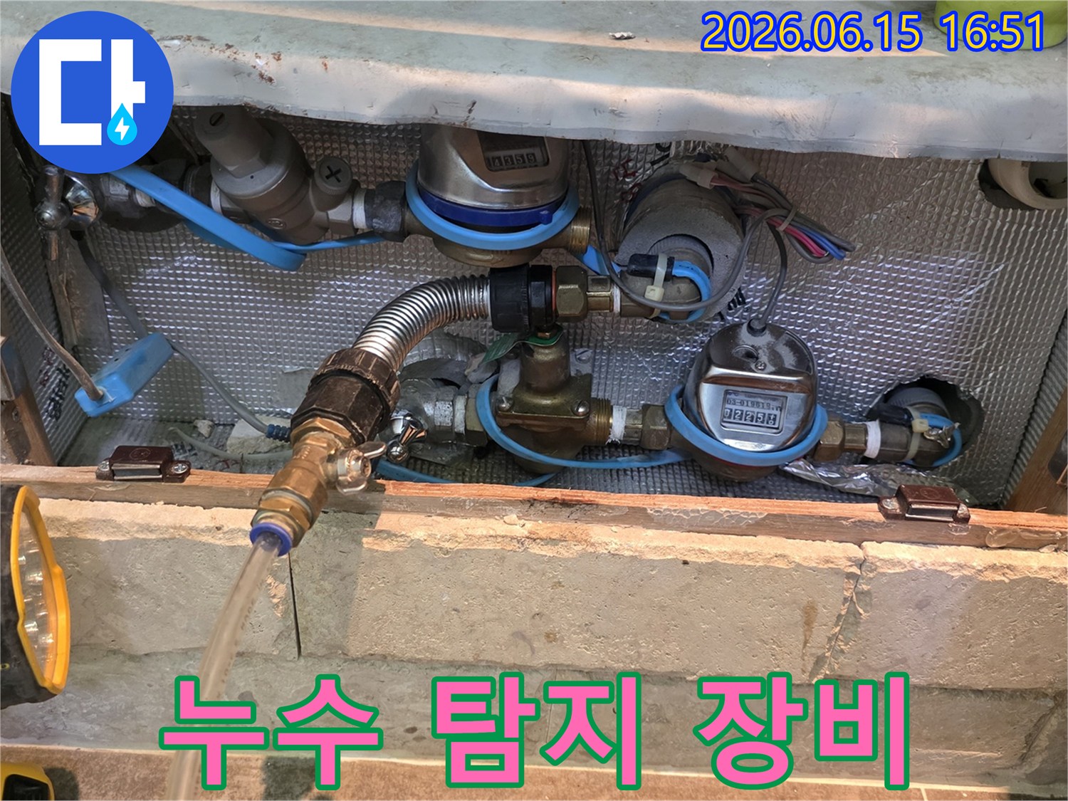 배관 연결부에 누수 탐지용 압력 게이지와 유량계를 설치하여 물이 새는 곳을 정밀하게 확인하는 장면입니다-누수 엔지니어의 전문적인 작업 과정입니다.