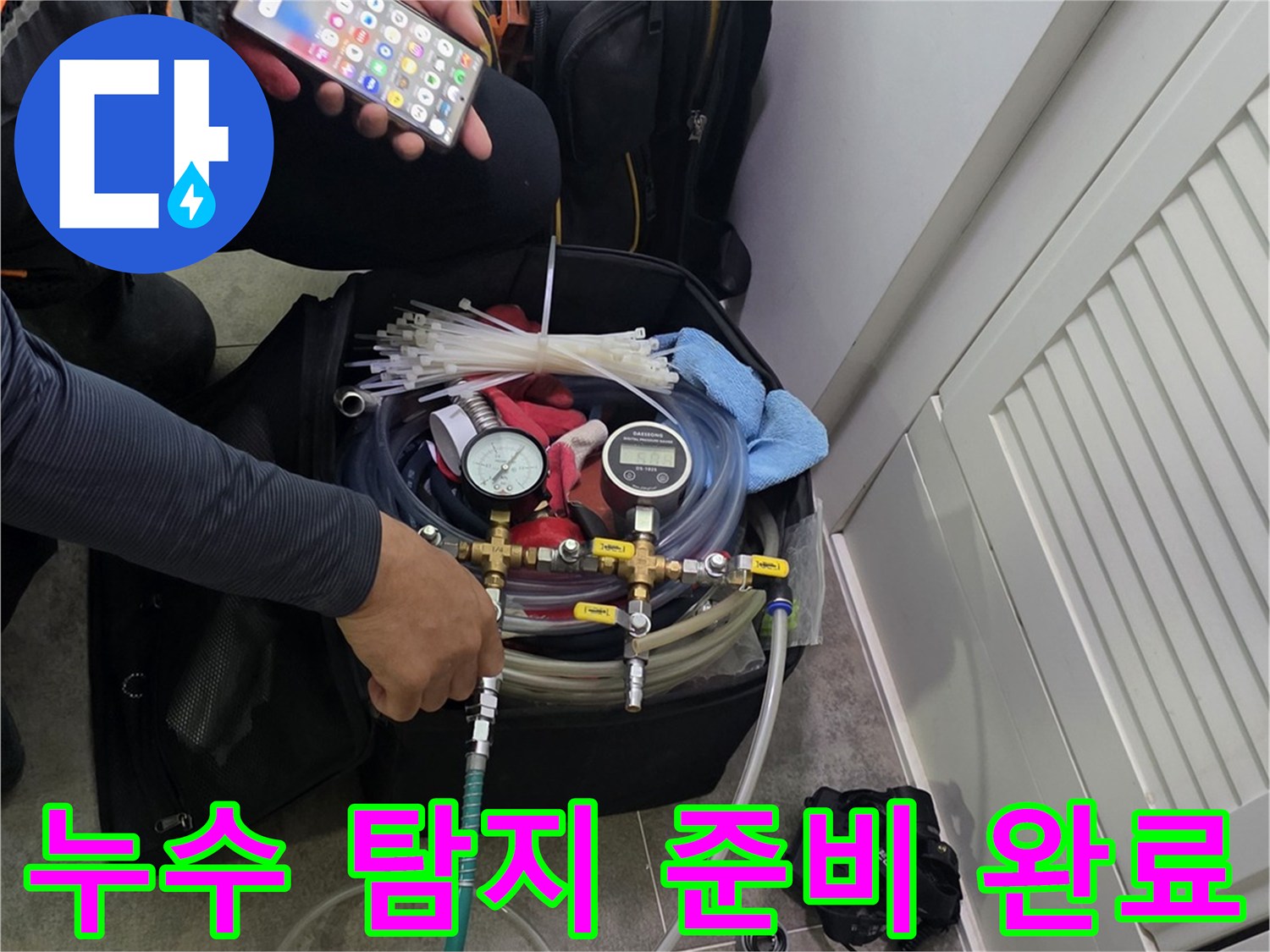 현장에서 누수 탐지 장비를-조작하며-스마트폰으로 데이터를 분석하는 엔지니어