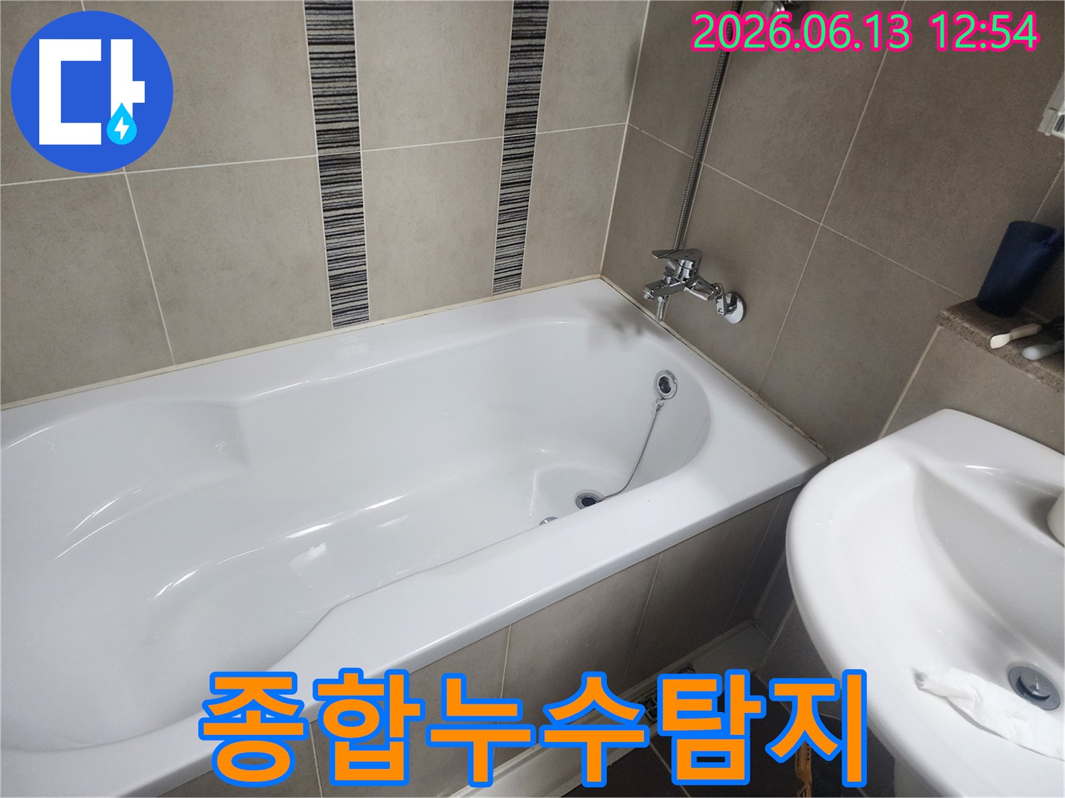 하얀 욕조와 주변 타일-다양한 장비를 활용한 종합적인 누수 탐지 준비 현장