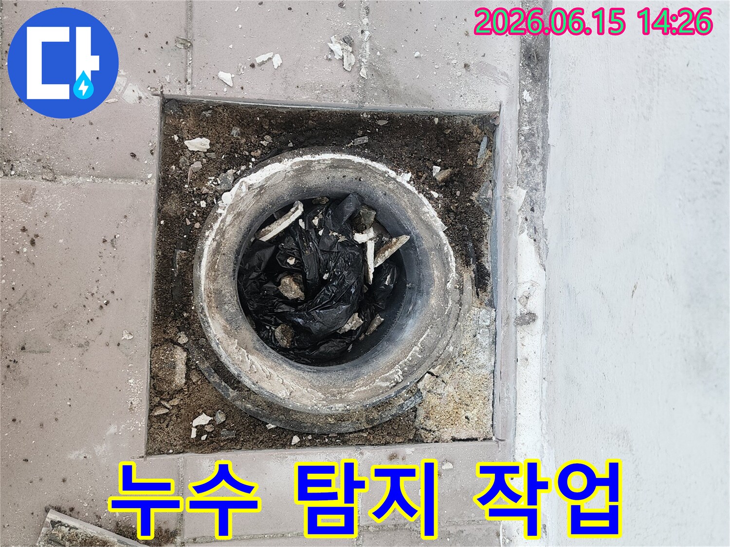 누수 지점을 찾기 위해-배관 입구를 노출시키고-내부에 쌓인 이물질을-관찰하는 현장 사진