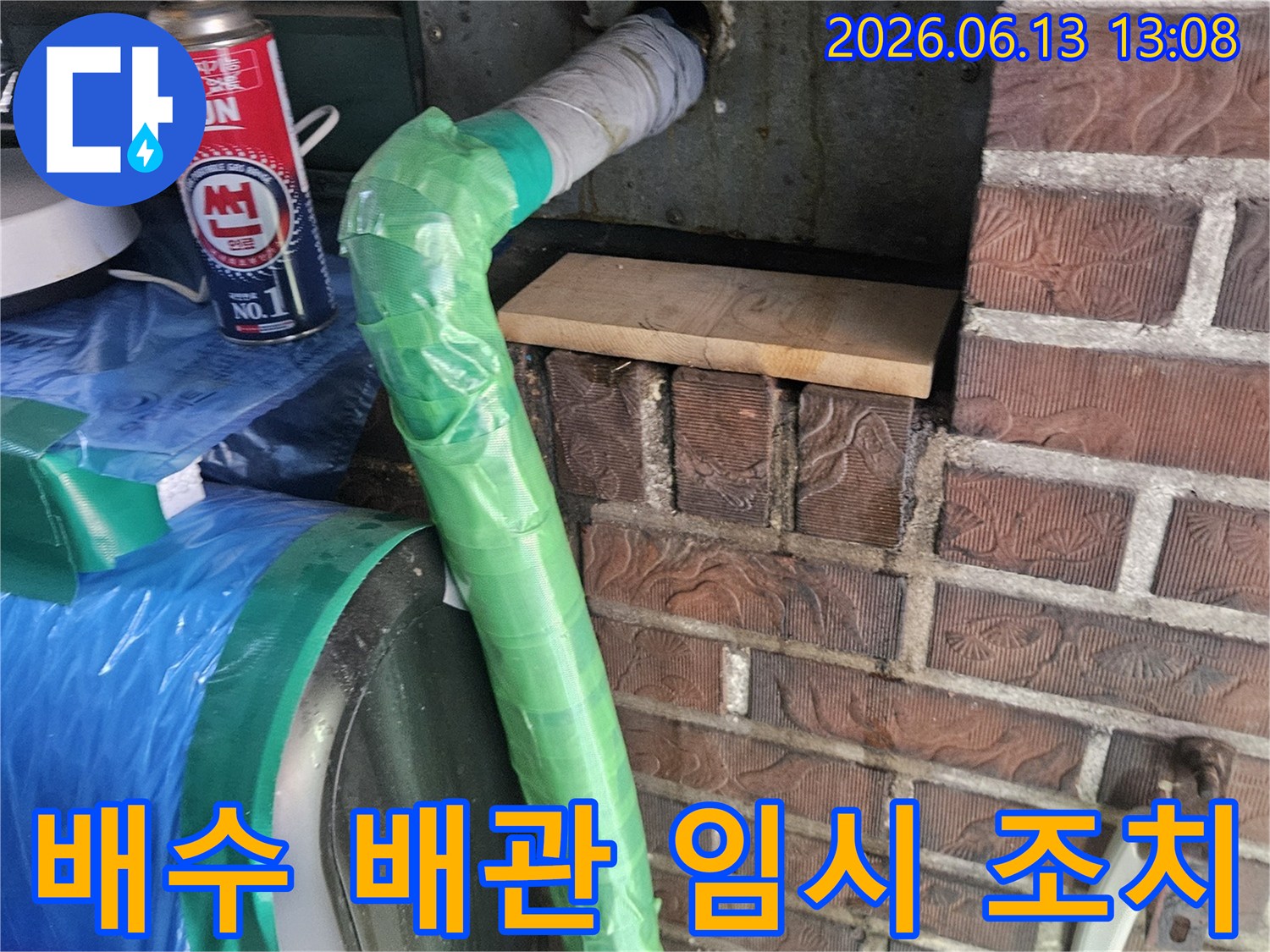 빌라 벽면에서 나온 배수 배관의 누수 지점을-특수 테이프로 감싸고 토치로 열처리하여 임시 조치하는 모습