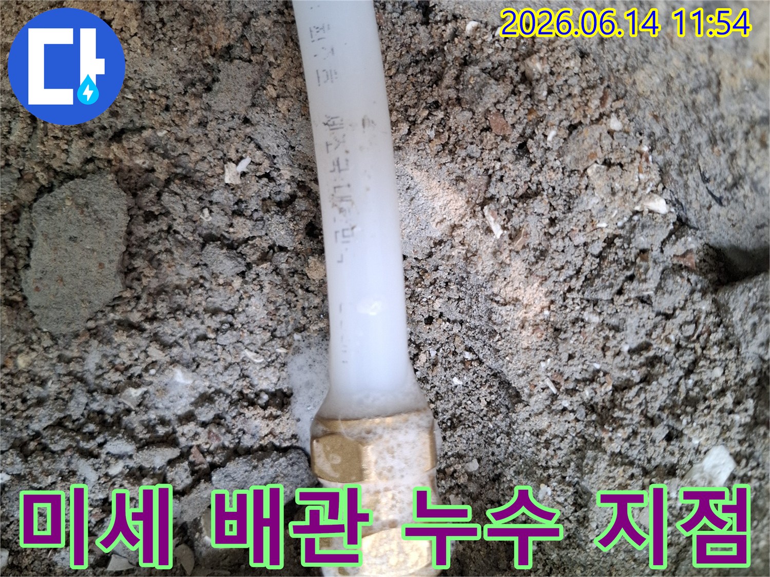 땅속에-매설된-배관의-연결부에서-미세하게-물이-새어나와-주변-흙이-젖어있는-누수-현장을-보여주는-사진