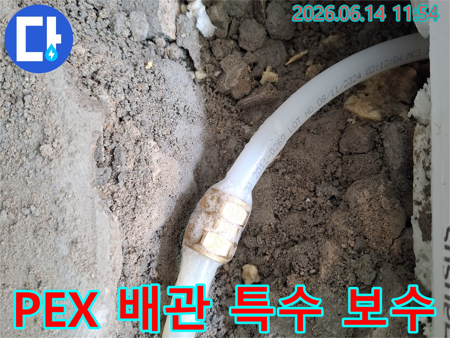 흙 속에 노출된-PEX 수도 배관의-손상된 연결 부위를-특수 자재로-보수하기 위해-준비 중인-누수 공사 현장 사진입니다