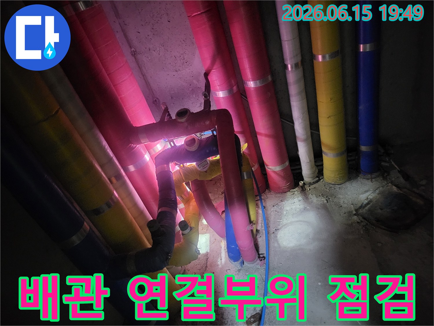 복잡하게-얽힌-다양한-색상의-배관-연결-부위를-전문-엔지니어가-누수-여부를-확인하기-위해-집중적으로-점검하는-모습입니다