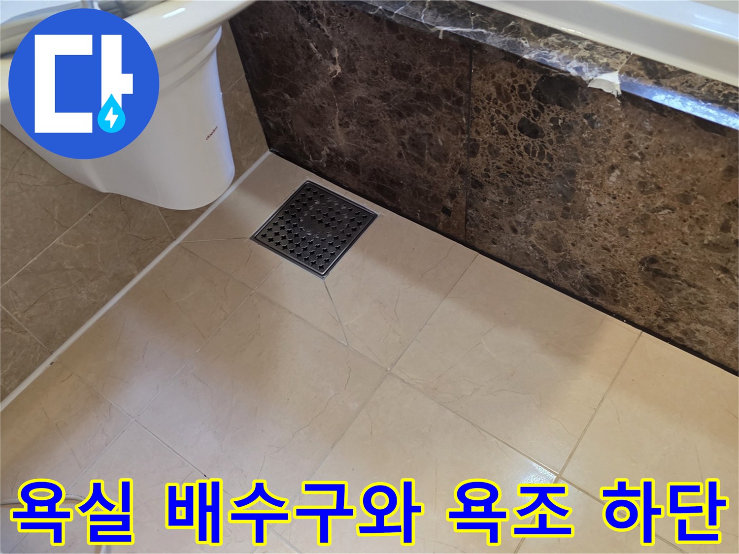 검은색 배수구 덮개와 대리석 패턴의 욕조 측면