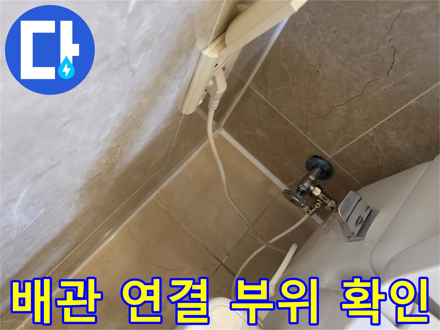 화장실 벽면 하단-배수구와 배관의 접합 상태를 근접 촬영한 사진