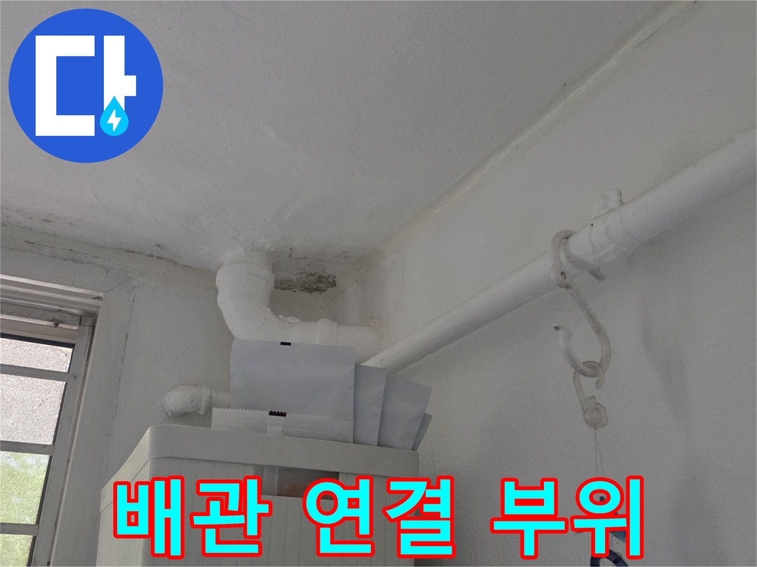 천장에 설치된 하얀색 배관과 벽면의 습윤한 얼룩 상태
