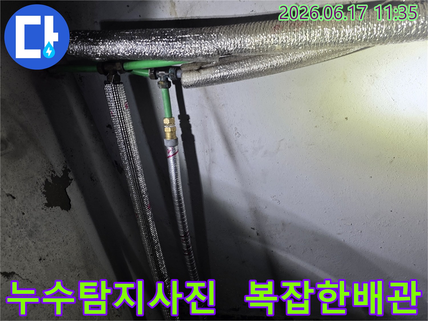 누수 공사 현장에서-발견된-녹색 배관과-은색 보온재로 감싸인-수도관 연결부의 모습
