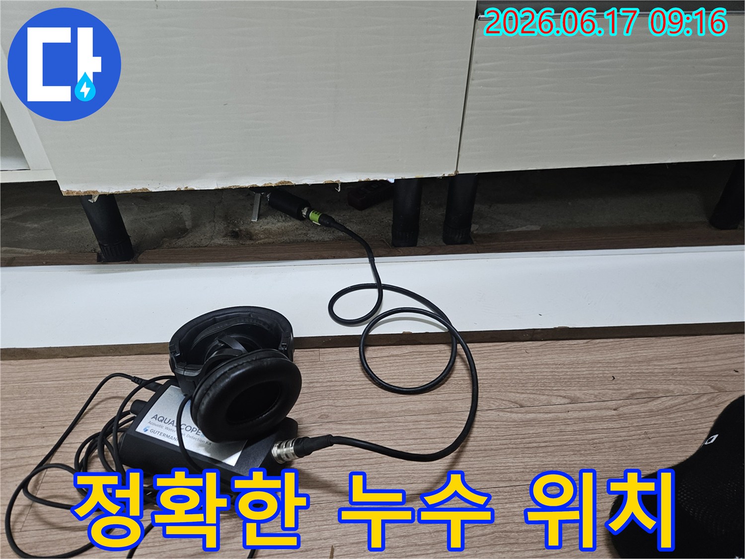 누수 탐지 엔지니어가-청음식 장비를 사용하여-싱크대 하부 배관의 정확한 누수 위치를 파악하는 모습