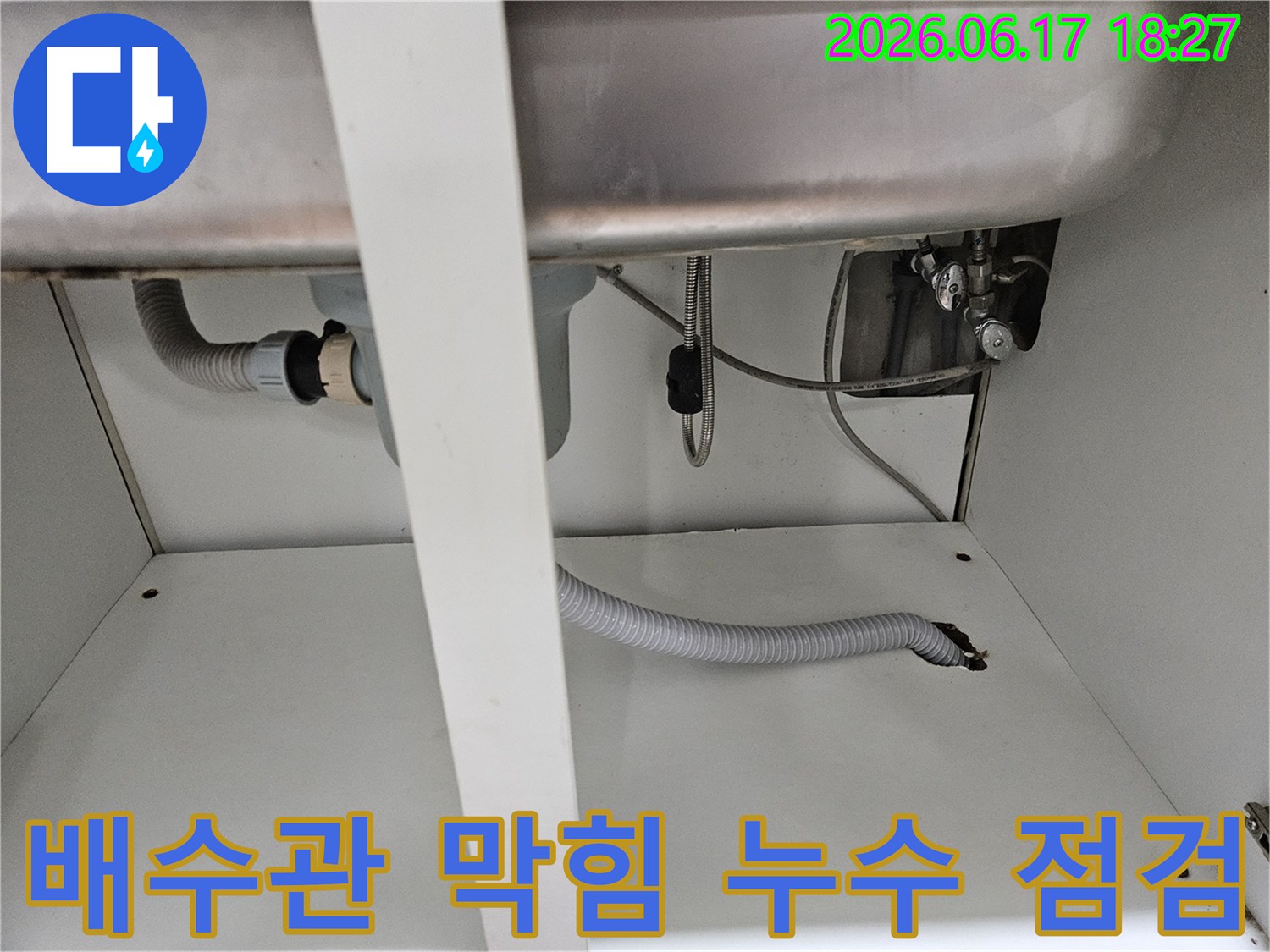 싱크대 하부 배관에서 발생한 배수관 막힘과-누수 문제를 동시에 점검하는 현장 사진입니다