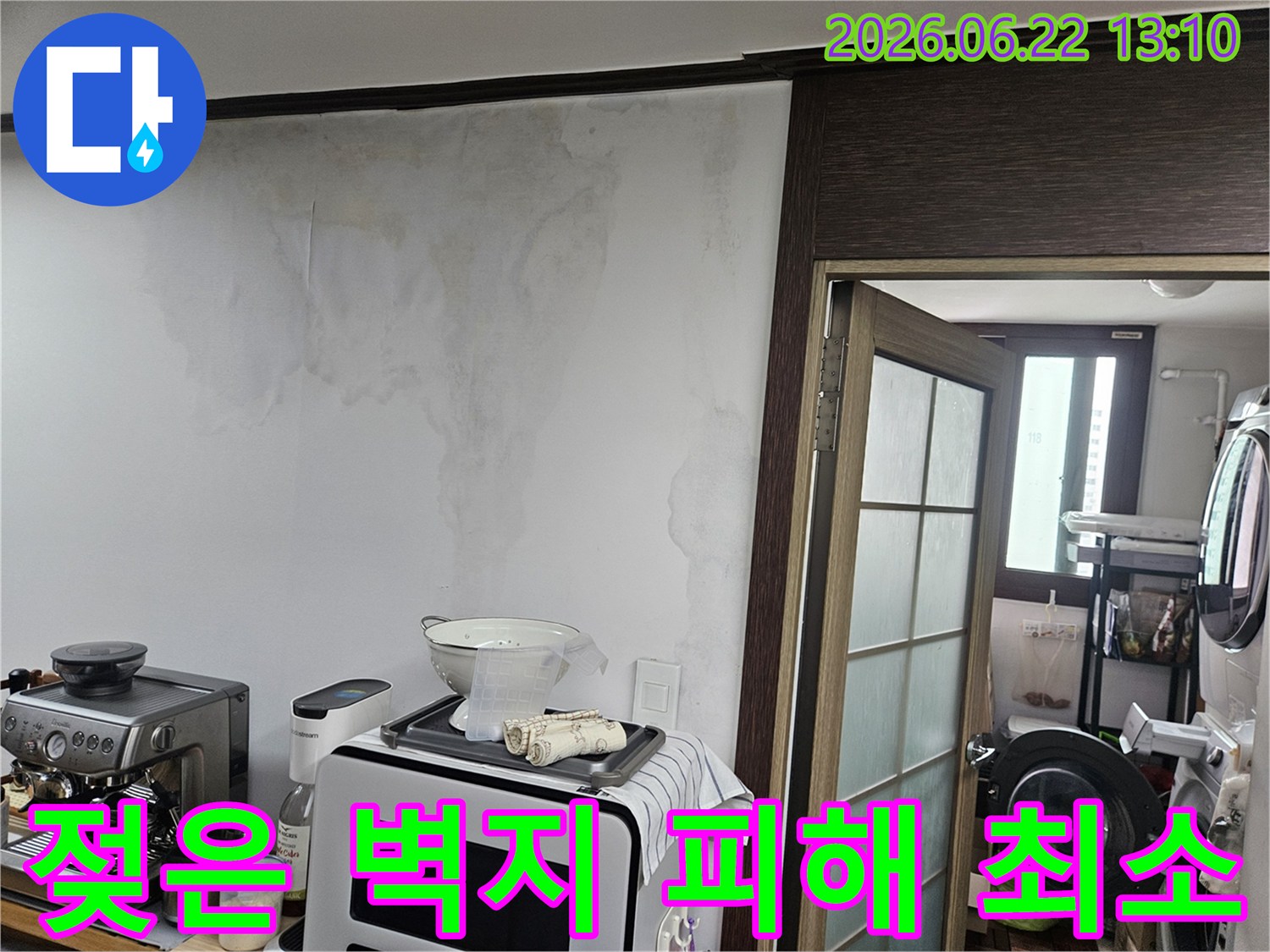 아파트 주방 벽면에 나타난-천장 누수로 인한-심각한 물자국과-벽지 손상 모습을 보여주는 사진