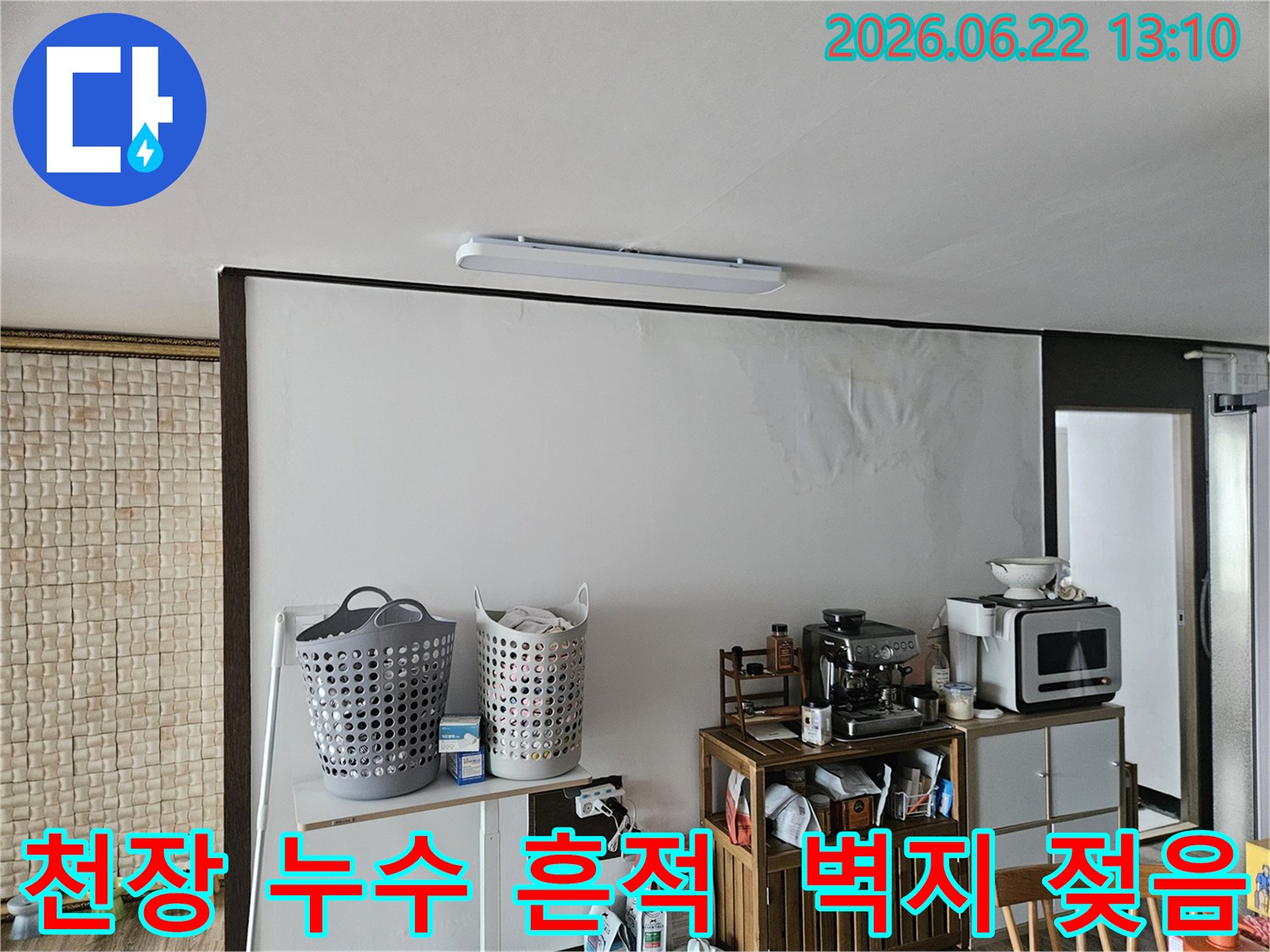 아파트 천장에서 물이 새어-벽지가 젖고 얼룩진 모습으로-누수 전문가가 현장을 확인하는 사진입니다