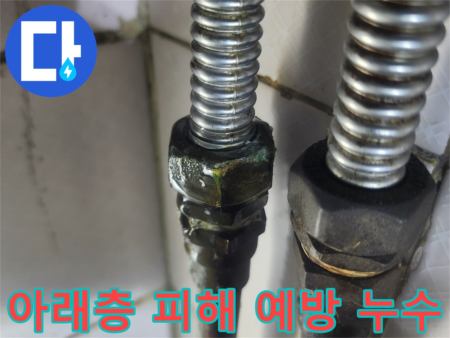 이 이미지는 노후된 온수배관의 연결 부위에서-녹색 부식과 함께 물이 새는-아래층으로의 피해를 막기 위한 신속한 조치가 필요한 누수 현장을 보여줍니다.