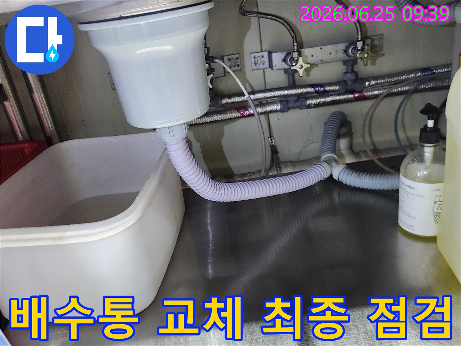 대형 싱크대 배수통 교체 작업이 완료된 후-누수 여부를 확인하기 위해 물을 사용하며 점검하는 모습