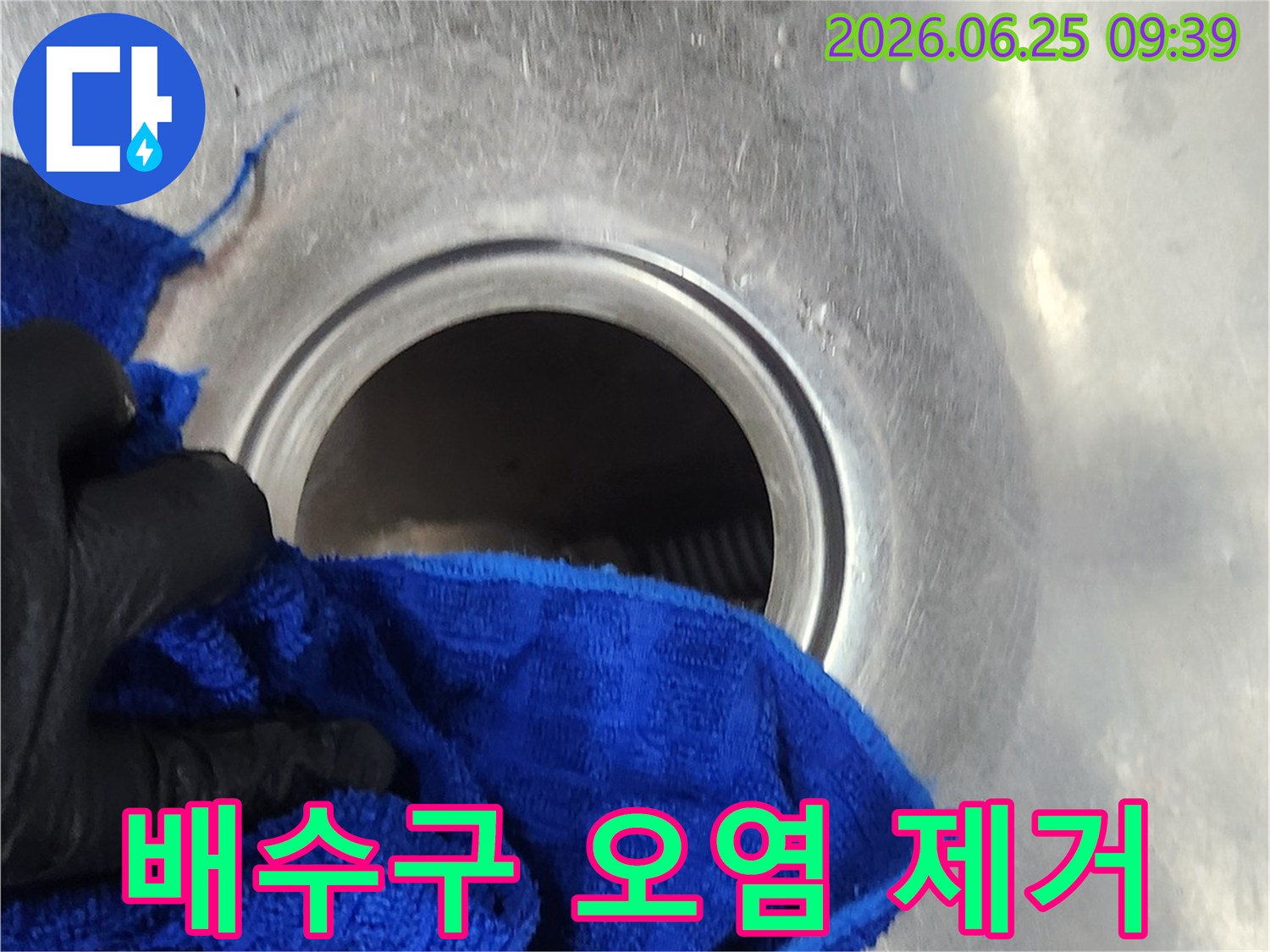 작업자가-새로운-배수통-설치-전-배수구의-오염물을-제거하는-장면입니다